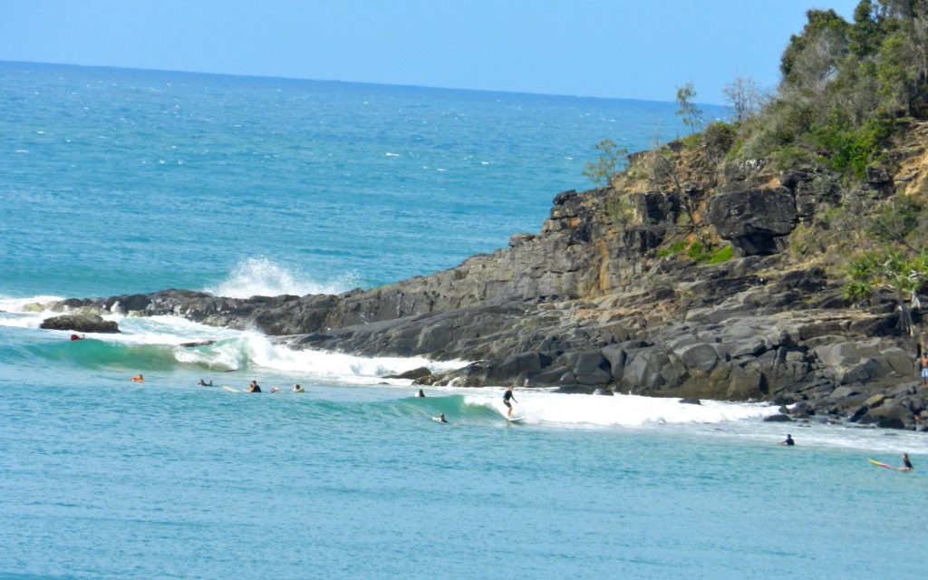 plage, rochers et surfeurs